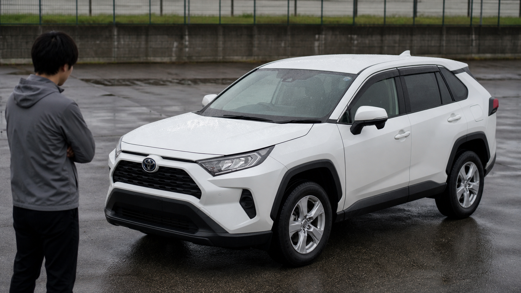 雨上がりの屋外駐車場でトヨタ RAV4に残った水滴を施工前に確認するイメージ